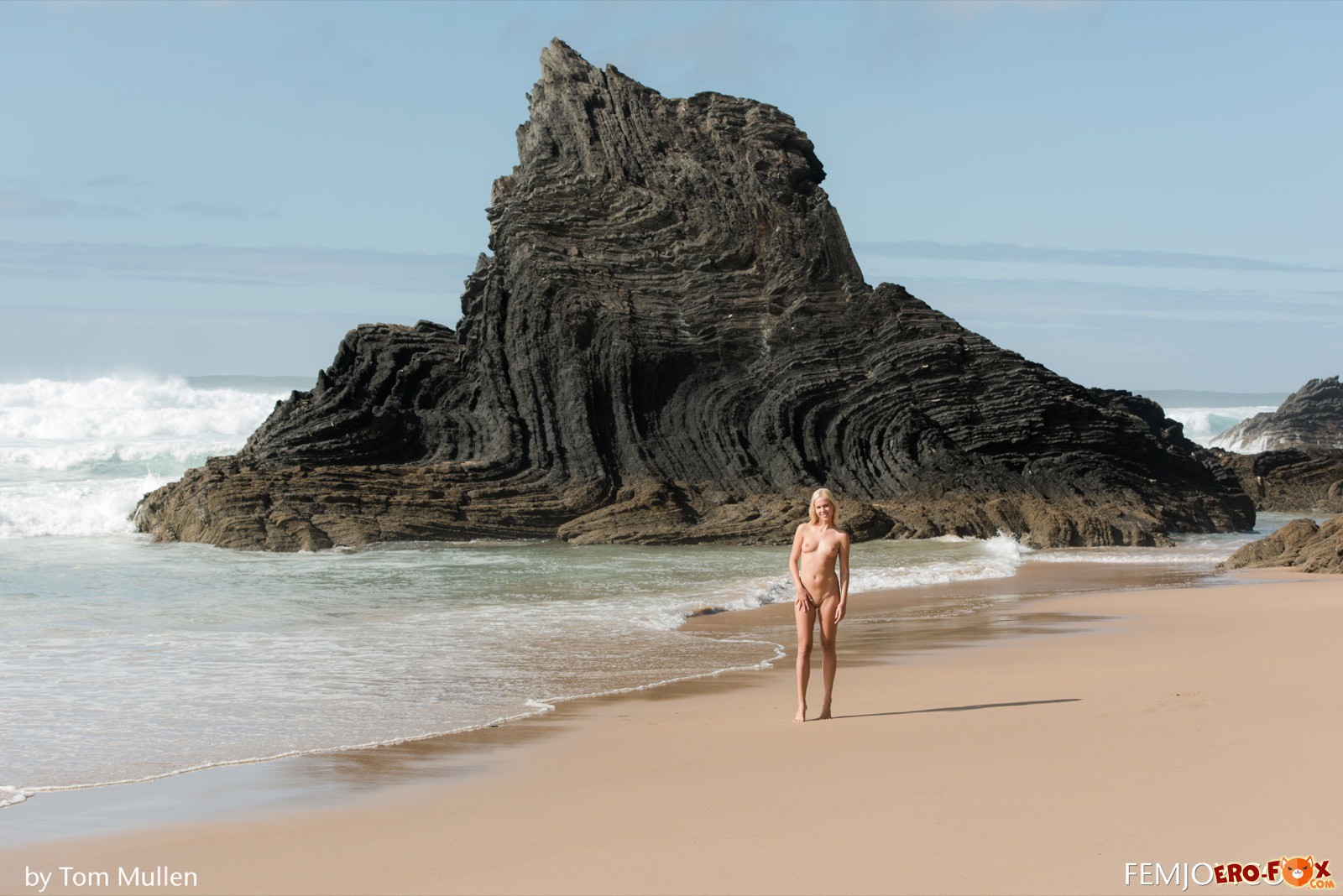 Сексуальная блондинка без одежды гуляет по пляжу